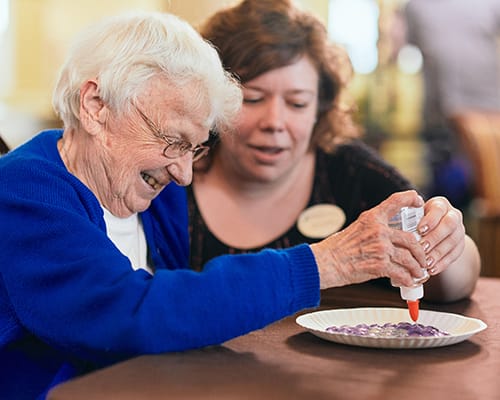 caregiver helping a resident with a craft