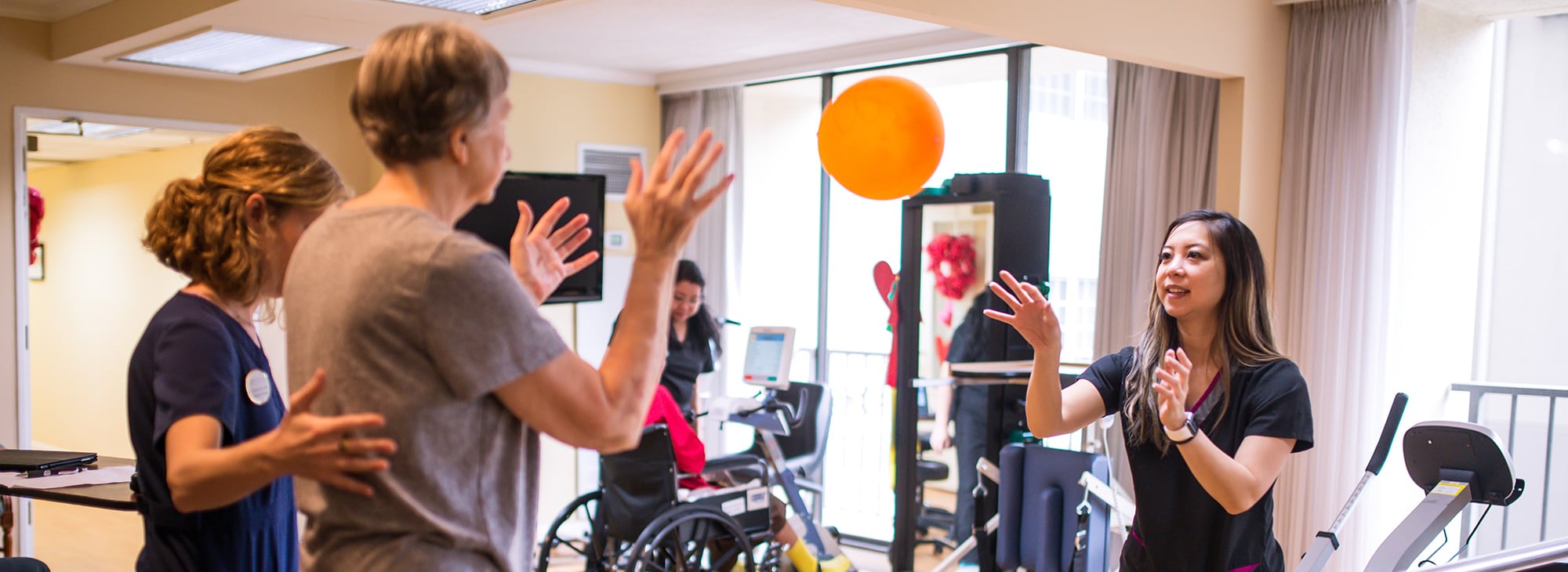 two female caregivers working on rehab with a resident